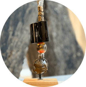 Pendentif Bwa du Burkina-Faso, tube de corne de zébu, perle Tiv du Nigéria et perle de verre de Murano montés sur bandes de tissus de lin et soie.