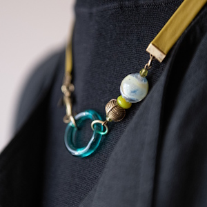 Collier Amilune Sonia composé d'une lanière en cuir d'agneau, d'un anneau de verre de Murano, d'une perle de verre de Murano et d'une perles de bronze Akan du Ghana.