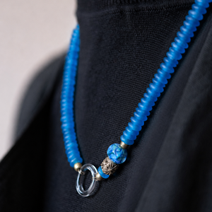 Collier Amilune Tamara composé d'un enfilage de perles disque de pâte de verre africaine, d'un anneau de verre de Murano, d'une perle de verre de Murano et d'une perles de bronze Akan du Ghana.
