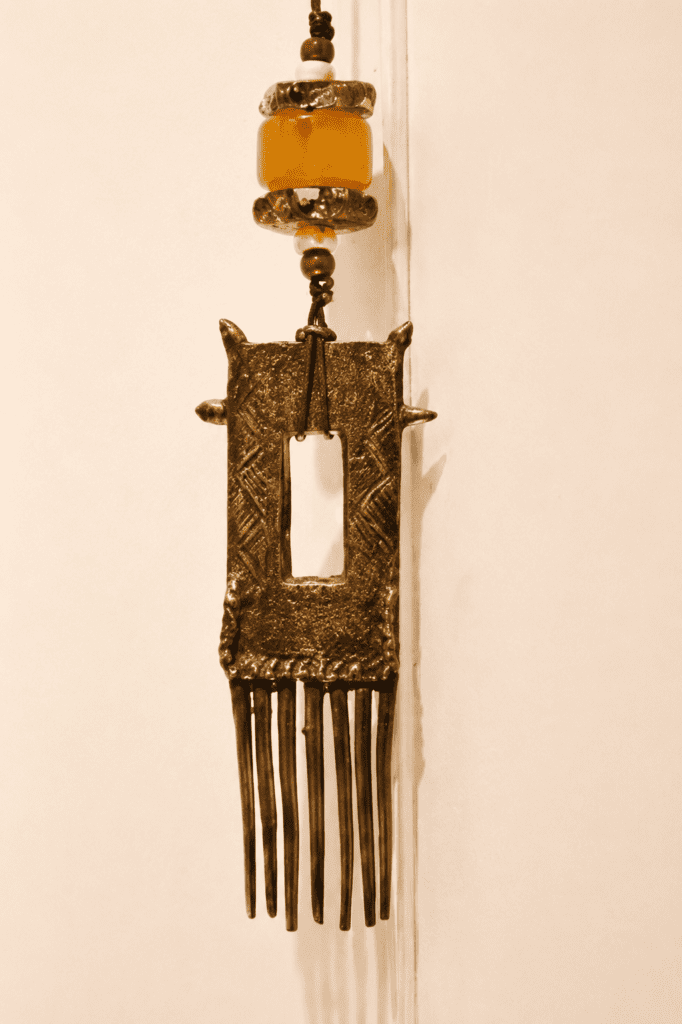Peigne Dogon du Mali surmonté de deux perles de verre de Murano et d'une perles d'ambre. l'ensemble monté sur cordon de cuir.