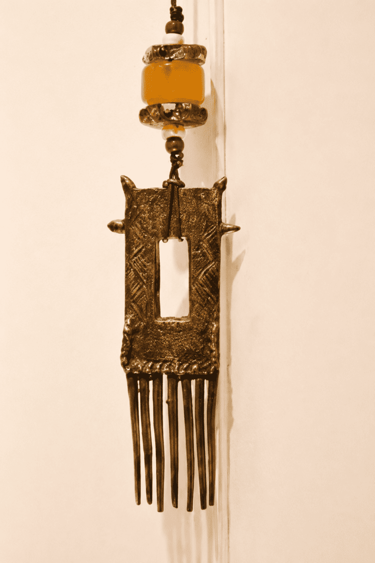Peigne africain surmonté de deux perles de verre de Murano et d'une perles d'ambre. l'ensemble monté sur cordon de cuir.