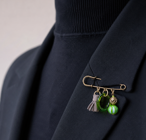 Broche Amilune Sonia composée d'un anneau de verre de Murano, d'une perle de verre de Murano, d'une perles de bronze Akan du Ghana et d'un ponpon de cuir d'agneau.